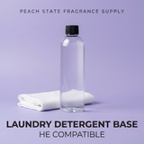 Clear laundry detergent bottle with a black cap on a purple background, featuring 'Peach State Fragrance Supply' branding.